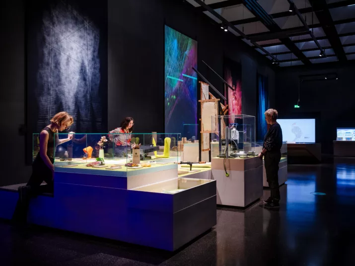 Drei Menschen sehen sich Exponate im Lab an