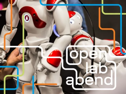 Auf dem Bild mit OLA Branding sind zwei rot-weiße Roboter zu sehen.
