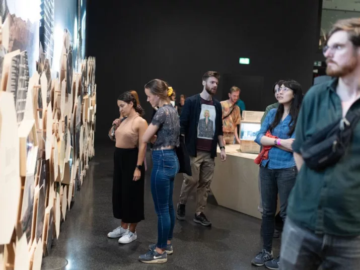 Eine Gruppe von Menschen schaut sich in der Ausstellung ein Wandbild an