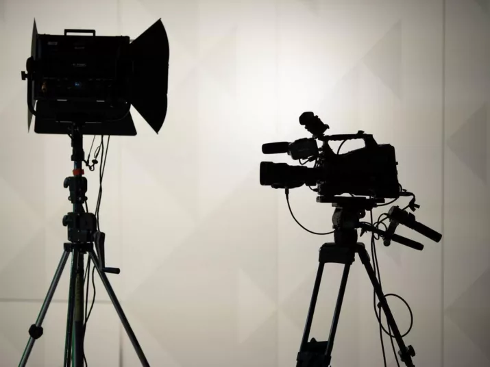 Die Schatten zweier Kameras vor einer hellen Wand